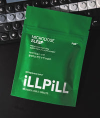 Lifestyle photo of an iLLPiLL MicroDose Sleep 30-tablet green package resting on a music synthesizer